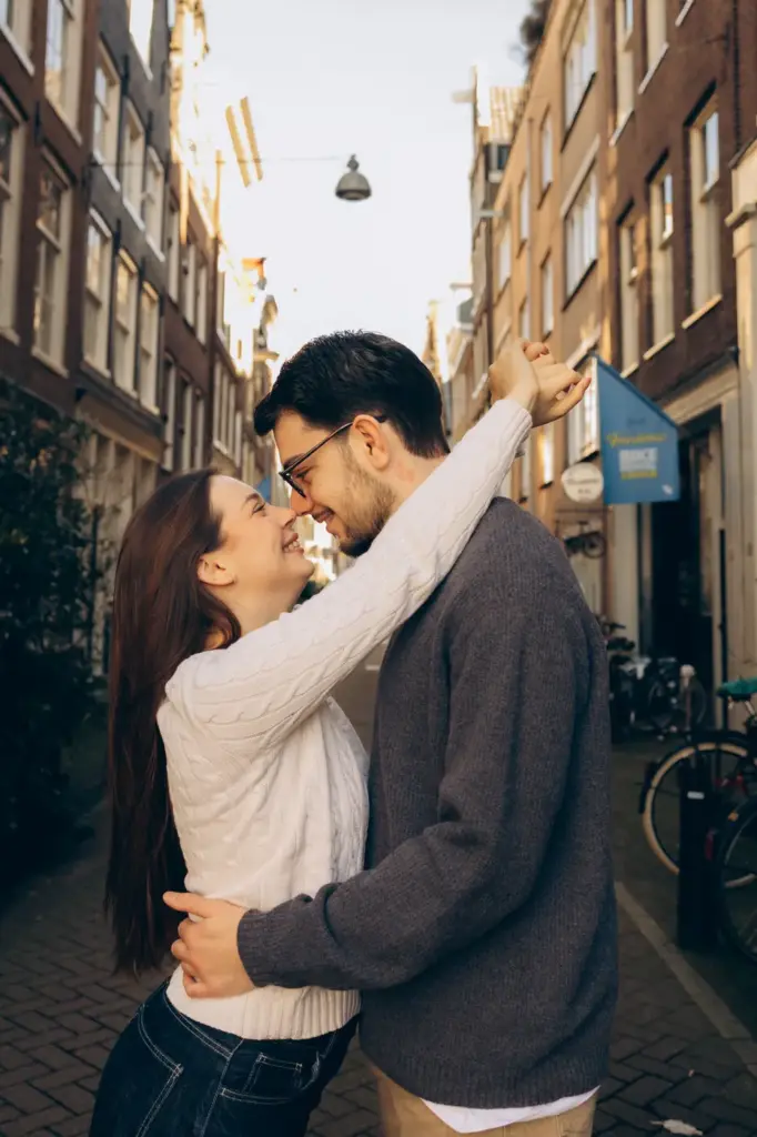 Couple kissing in a narrow Amsterdam street in warm light