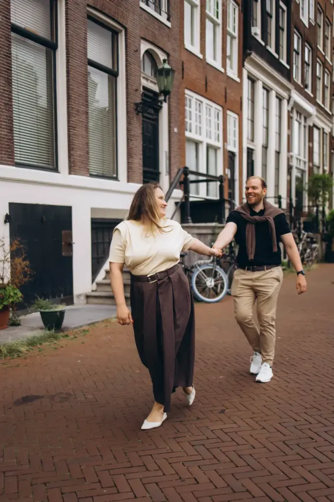 Couple walking along an Amsterdam street past a bicycle