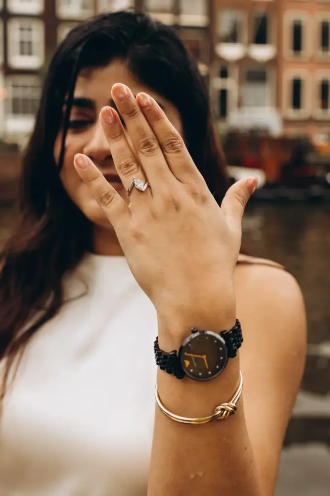 Woman showing her engagement ring and laughing after the proposal in Amsterdam