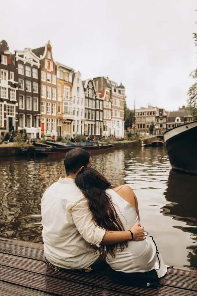 Couple sitting together at the edge of a canal after the proposal